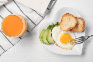 Delicious over easy egg with toasts and avocado on kitchen table
