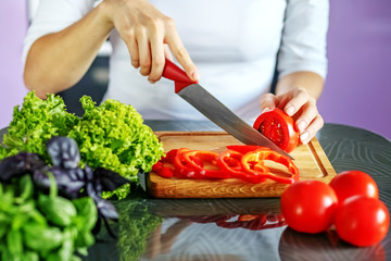 The mistress slicers vegetables in the kitchen. The concept is healthy food, diet, vegetarianism, weight loss.
