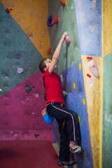 girl rock climber working on the problem bouldering in climbing shoes