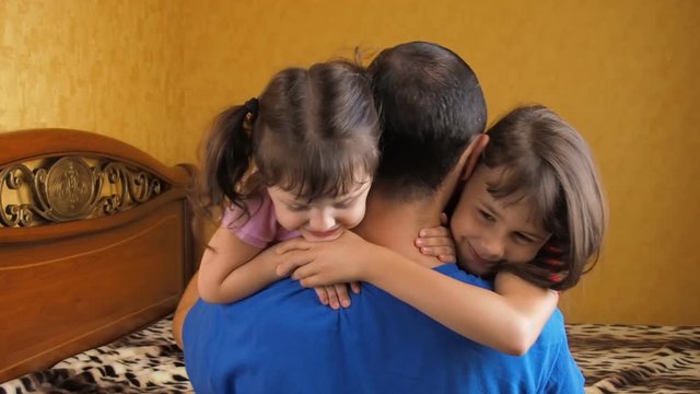 Children hugging dad. Father hugging daughters.