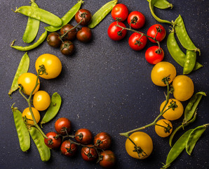 Food cooking background with red and yellow tomatoes and green pea. Copy space, top view