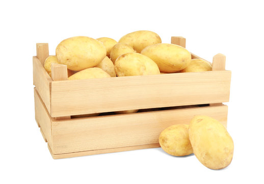 Wooden box with potatoes on white background