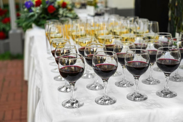 Many glasses of different wine on festive table