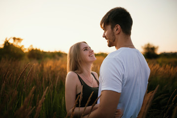 Romantic Couple at Sunset. Two people in love at sunset or sunrise. Man and woman on field