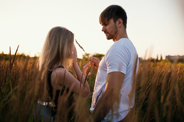 Romantic Couple at Sunset. Two people in love at sunset or sunrise. Man and woman on field