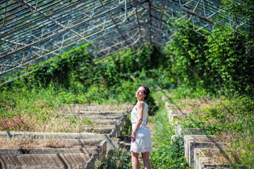 girl in short white Board is in an abandoned greenhouse