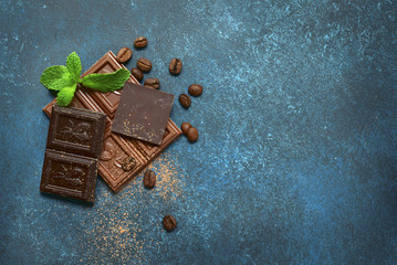 Chocolate slices with mint leaves and coffee beans.Top view with space for text.