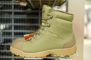 Winter green boots for outdoor activities on stands in sport store