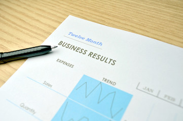 Business report on a wood tabletop with a pen