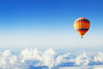 inspiratie of reisachtergrond, vlieg boven de wolken, kleurrijke heteluchtballon in blauwe lucht
