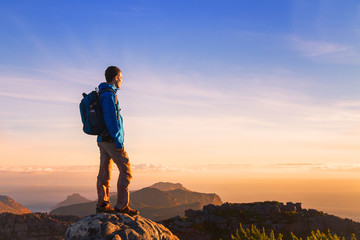 Fototapeta premium turysta na szczycie góry z widokiem na zachód słońca z copyspace