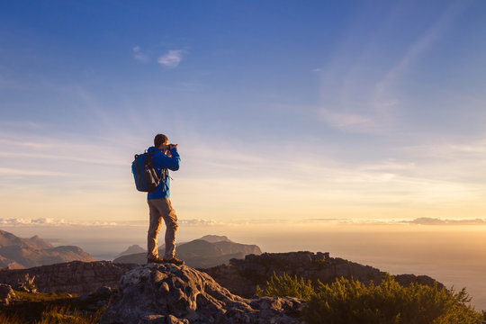 nature photographer traveler taking photo of beautiful landscape from top of the mountain