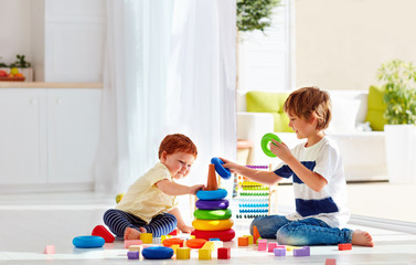 elder brother playing with junior baby boy at home