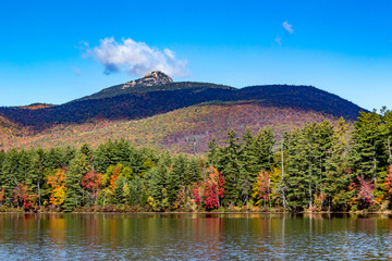 Fall foliage on the lake with mountain backdrop in New Hampshire