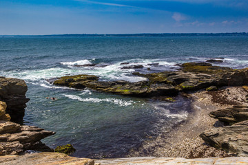 Fototapeta na wymiar Hidden beach among rocky coast in Jamestown, Rhode Island