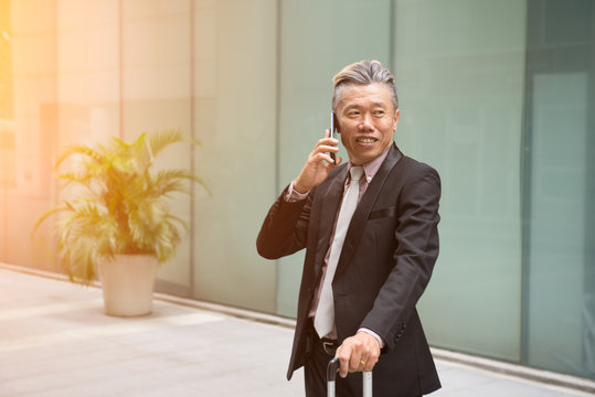 Asian Senior Businessman Travel With Phone