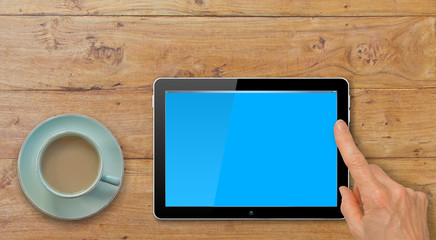 Computer Tablet with Hand Pointing or Swiping on Table by Coffee or Tea cup

