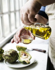 Closeup of hands pouring virgin olive oil