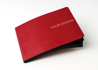 Closeup of red cover notebook on white table