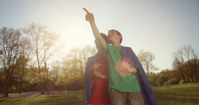 Cute young boy in green shirt pointing up at sky