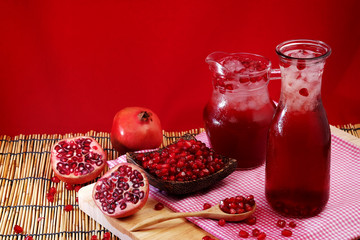 Pomegranate Set. Good healthy by Pomegranate seed on wooden spoon and cool Pomegranate juice set on red Themes tone background. have some space for write wording