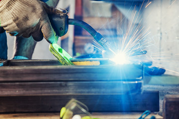 man welds a metal welding machine