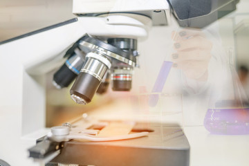 Microscope on the table in laboratory room with laboratory equipment