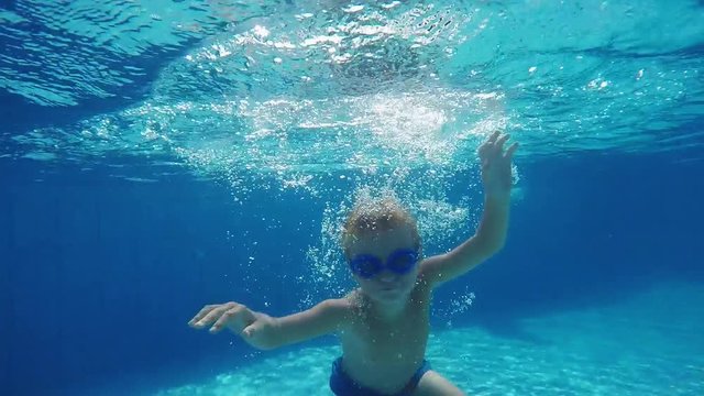 Boy in Glasses Jumps and Dives Under Water