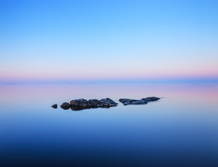 Tranquil minimalist landscape  with rocks in calm water.