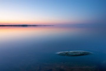 Fototapeta na wymiar Tranquil minimalist landscape with rock in calm water