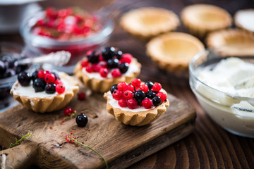 Making black and red currant tart with cottage cheese