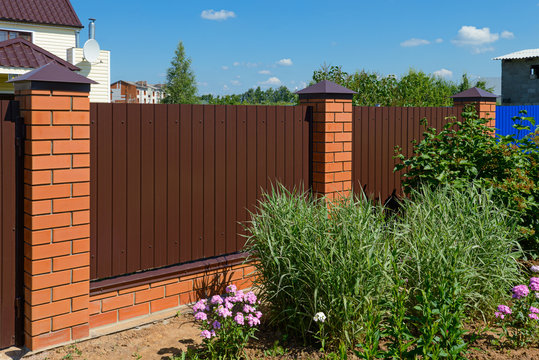 Fence made of metal profile with brick poles