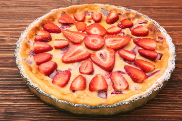 Tart with fresh strawberry on wooden background