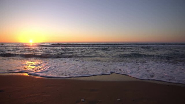 Sunset waves on an empty beach, wide angle shot