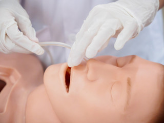 Close-up detail of a physician inserting a nasogastric tube into a training model. Healthcare and education concept. - 164662152