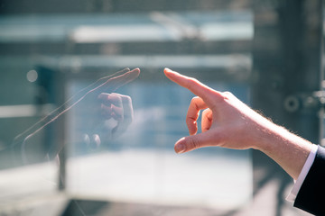 hand touching glass panel.