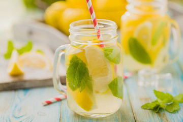 lemonade with mint on rocks served in jar with a straw