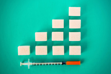 Insulin syringe and a diagram of cubes of sugar - Concept of diabetes