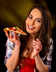 Woman eating slice of Italian pizza. Student consume fast food. Healthy eating and diet concept on black background. Girl cooked pizza at home.