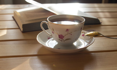 cup of tea and book on wooden table