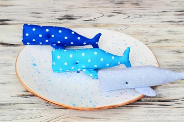 Foto op Aluminium Three textile soft toy blue whales in white specks on plate. Joy and friendship. Creativity and art. © watcherfox