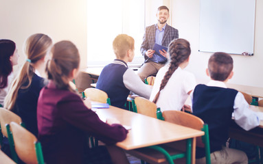 Pupils listening teacher in classroom