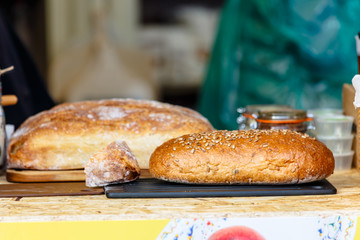 Rye and wheat bread with seeds lying on the counter on the street.