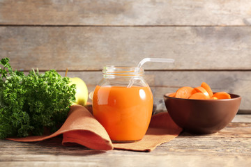 Jar of carrot juice on wooden table