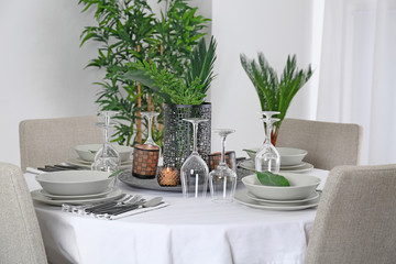 Beautiful table setting with green tropical leaves
