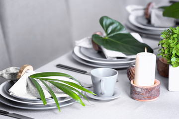 Beautiful table setting with green tropical leaves