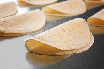 Yummy unleavened tortillas on metal kitchen table