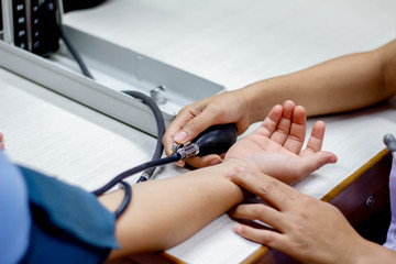 Doctor tests blood pressure of patients.