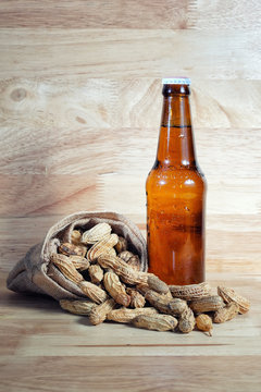 Boiled Peanuts and beer on wood background