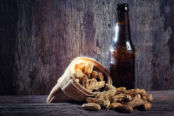 Boiled Peanuts and beer on wood background